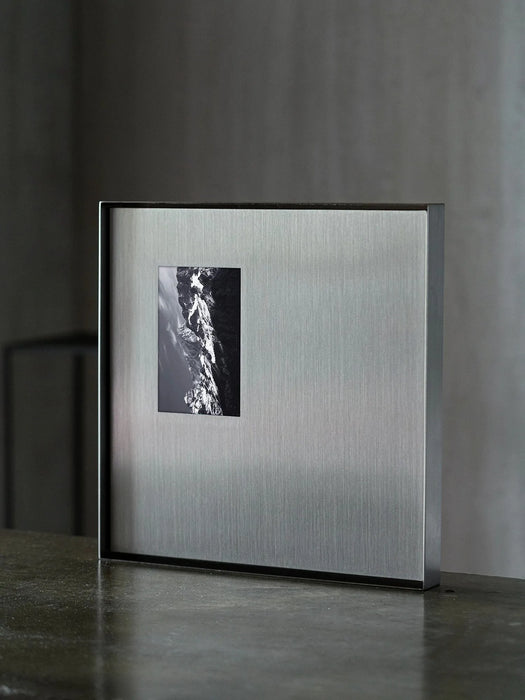 Square steel wall art panels arranged as a gallery wall grid